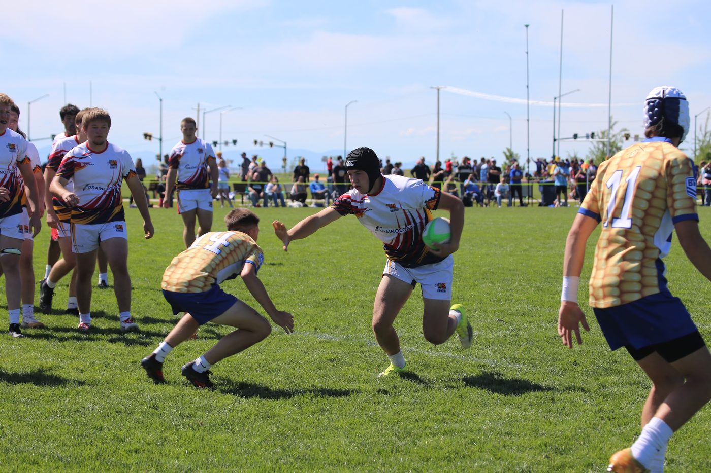 A ball carrier steps through a tackle in midfield