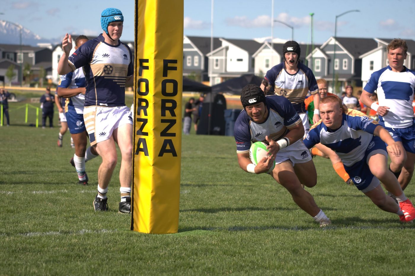 A player dives to ground the ball beside the posts