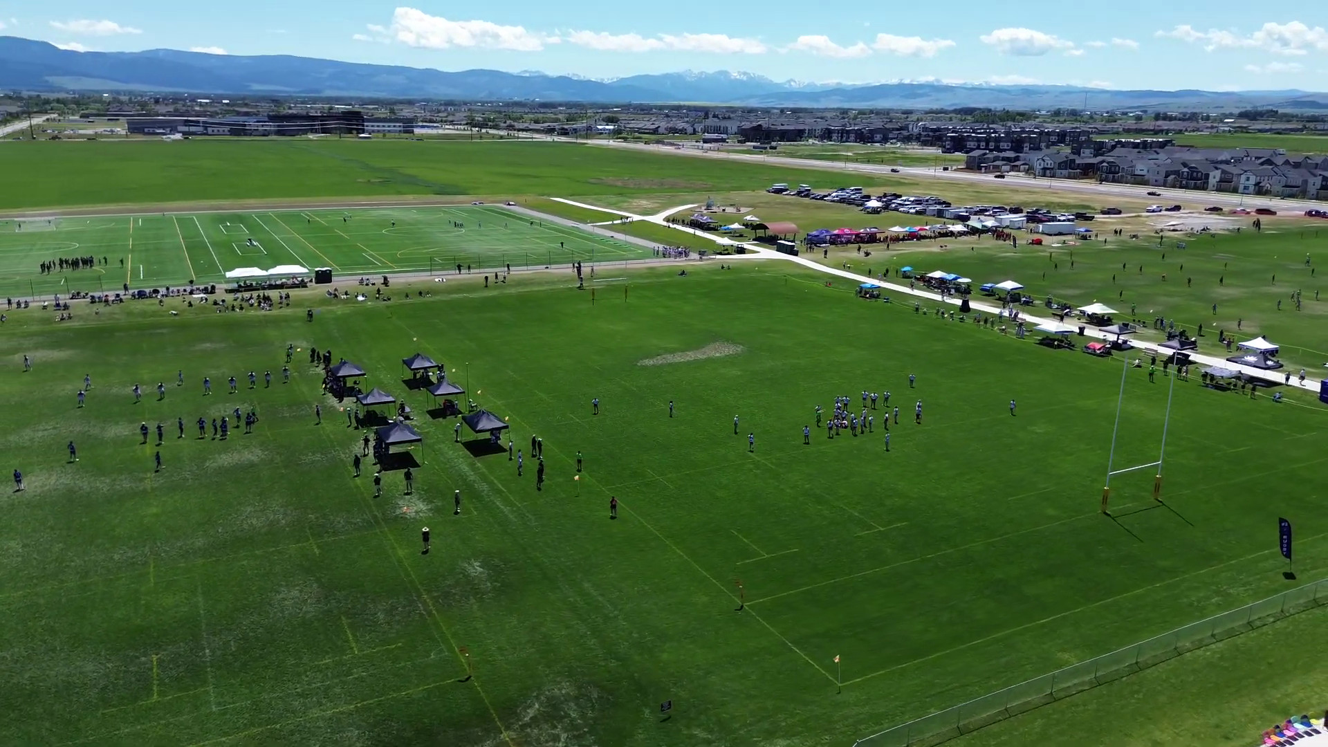 Aerial view of the rugby pitches at Bozeman Sports Park, with the Bridger range on the horizon